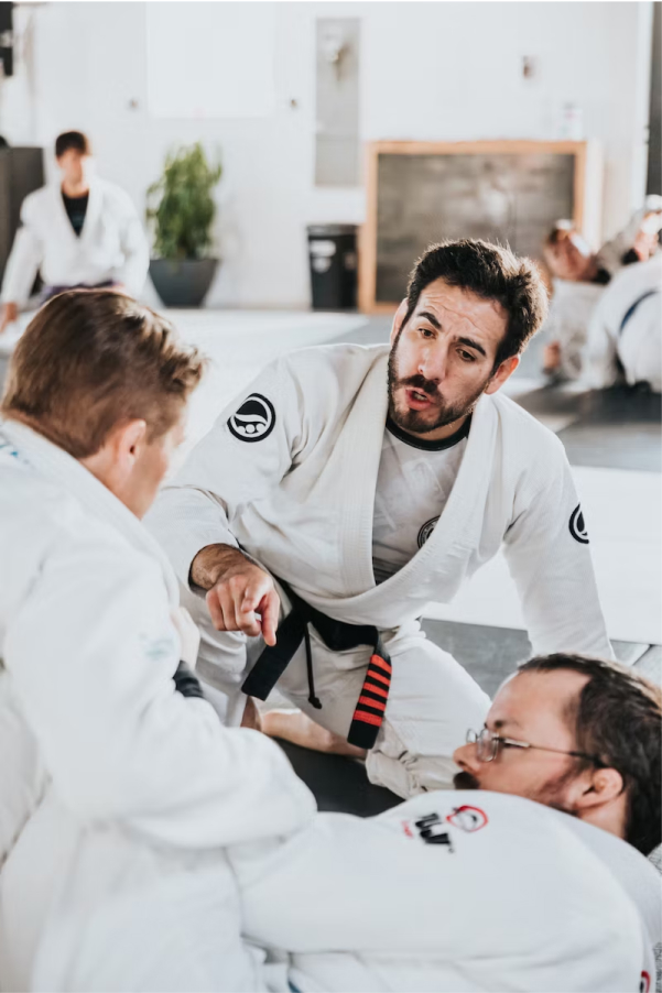 Instructor teaching a jiu-jitsu class in a gym
